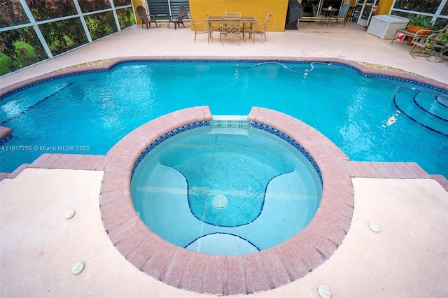 13290 SW 54th Ct, Miramar, FL 33027 - view of pool featuring a pool with connected hot tub, a patio, glass enclosure, and outdoor dining space