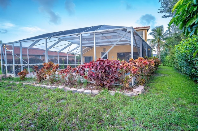13290 SW 54th Ct, Miramar, FL 33027 - rear view of property featuring a lawn, stucco siding, and glass enclosure