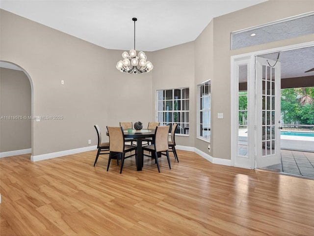 782 Lake Blvd, Weston, FL 33326 - dining room with light wood-style flooring, a chandelier, and arched walkways