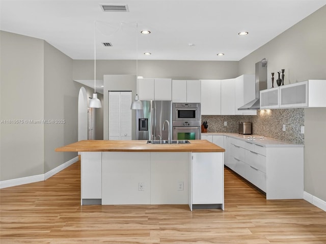 782 Lake Blvd, Weston, FL 33326 - kitchen with stainless steel appliances, wall chimney exhaust hood, light wood-style floors, white cabinetry, and recessed lighting