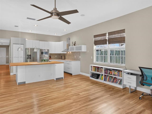 782 Lake Blvd, Weston, FL 33326 - kitchen featuring wall chimney exhaust hood, stainless steel appliances, light wood-style floors, white cabinets, and recessed lighting