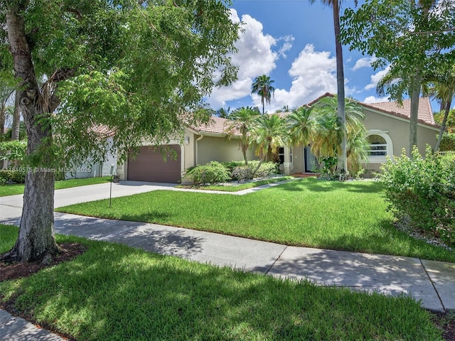 782 Lake Blvd, Weston, FL 33326 - view of front facade featuring stucco siding, concrete driveway, a tile roof, an attached garage, and a front lawn