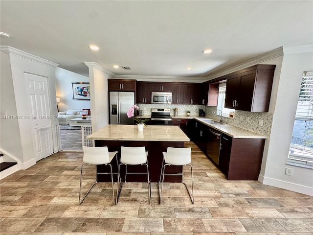 535 SW 181st Way, Pembroke Pines, FL 33029 - kitchen featuring stainless steel appliances, a kitchen breakfast bar, ornamental molding, decorative backsplash, and dark brown cabinetry
