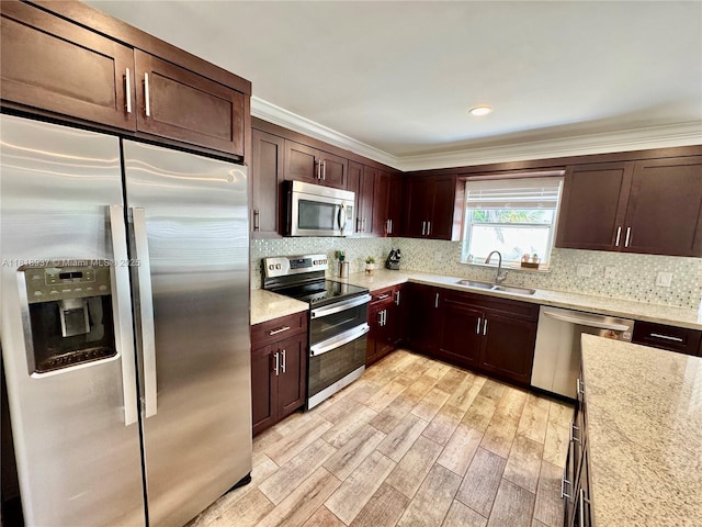 535 SW 181st Way, Pembroke Pines, FL 33029 - kitchen with stainless steel appliances, light wood-style flooring, ornamental molding, dark brown cabinets, and decorative backsplash
