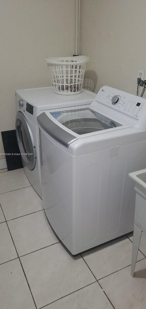4926 NW 48th Ave, Tamarac, FL 33319 - washroom with washing machine and dryer and light tile patterned floors