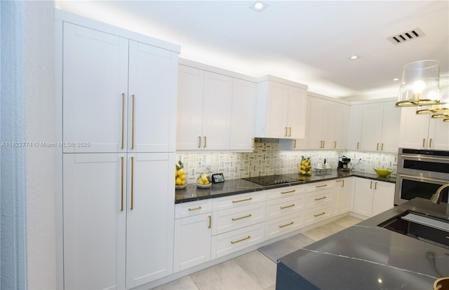 21420 SW 127th Pl, Miami, FL 33177 - kitchen featuring double oven, black electric cooktop, backsplash, white cabinets, and recessed lighting