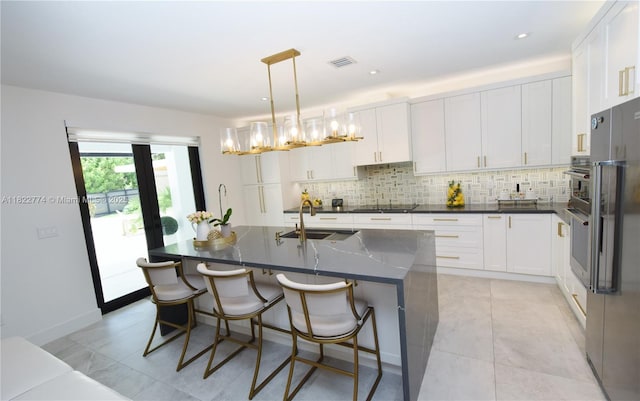 21420 SW 127th Pl, Miami, FL 33177 - kitchen featuring tasteful backsplash, white cabinets, black electric cooktop, a kitchen bar, and recessed lighting