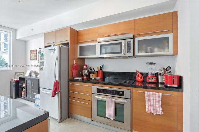 253 NE 2nd St Unit 1108, Miami, FL 33132 - kitchen featuring stainless steel appliances, dark countertops, and brown cabinets