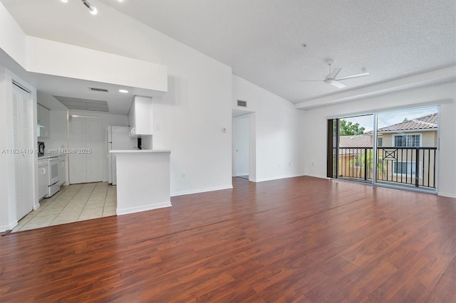 4183 N Haverhill Rd Unit 710, West Palm Beach, FL 33417 - unfurnished living room featuring ceiling fan, light wood finished floors, and high vaulted ceiling