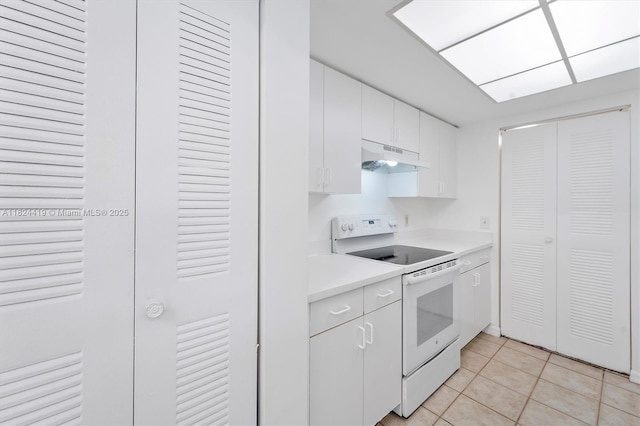 4183 N Haverhill Rd Unit 710, West Palm Beach, FL 33417 - kitchen with electric range, under cabinet range hood, light countertops, light tile patterned flooring, and white cabinetry