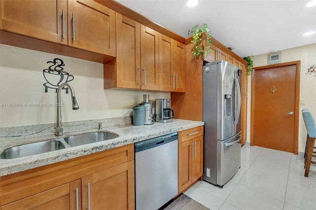 13705 SW 84th St Unit H, Miami, FL 33183 - kitchen with stainless steel appliances, light stone counters, brown cabinets, recessed lighting, and light tile patterned flooring