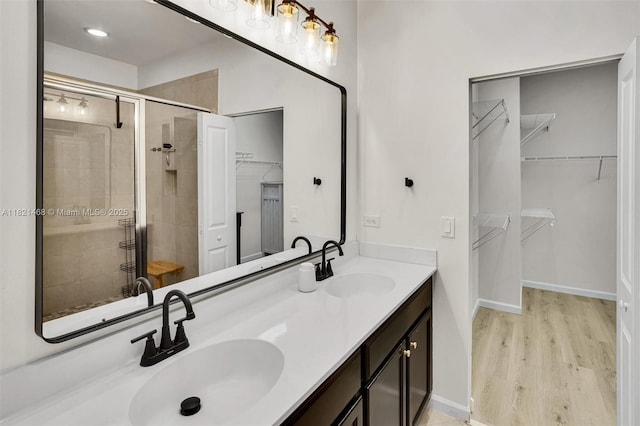 8144 Cascada Isles Dr, Cooper City, FL 33024 - full bathroom featuring double vanity, a shower stall, a spacious closet, and wood finished floors