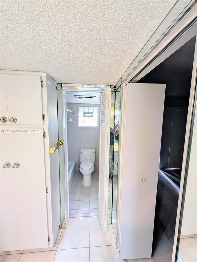 14901 SW 4th St Unit 9A, Pembroke Pines, FL 33027 - full bathroom with tile patterned floors, a textured ceiling, and a bathtub