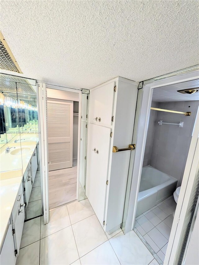 14901 SW 4th St Unit 9A, Pembroke Pines, FL 33027 - full bathroom with double vanity, tile patterned floors, a textured ceiling, and bathing tub / shower combination