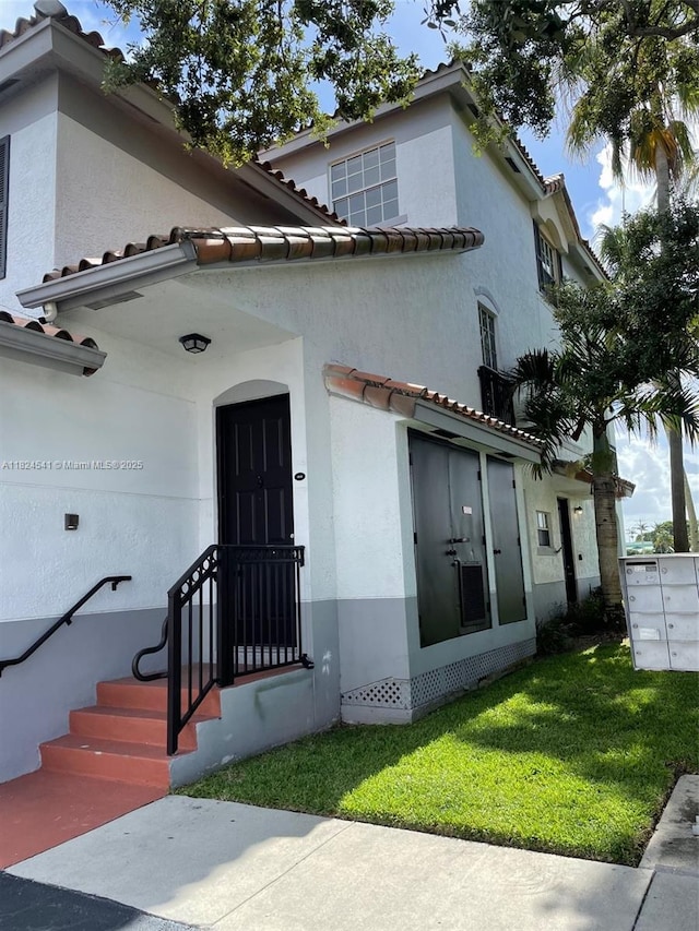 711 SW 148th Ave Unit 414, Sunrise, FL 33325 - view of front facade with a tiled roof, stucco siding, and a front yard