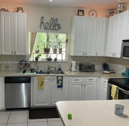 4812 Washington St Unit 8, Hollywood, FL 33021 - kitchen featuring appliances with stainless steel finishes, white cabinets, and light countertops
