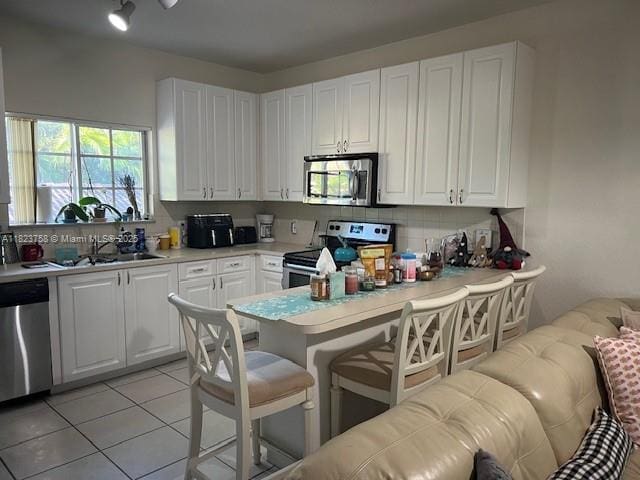 4812 Washington St Unit 8, Hollywood, FL 33021 - kitchen with appliances with stainless steel finishes, white cabinets, and light countertops