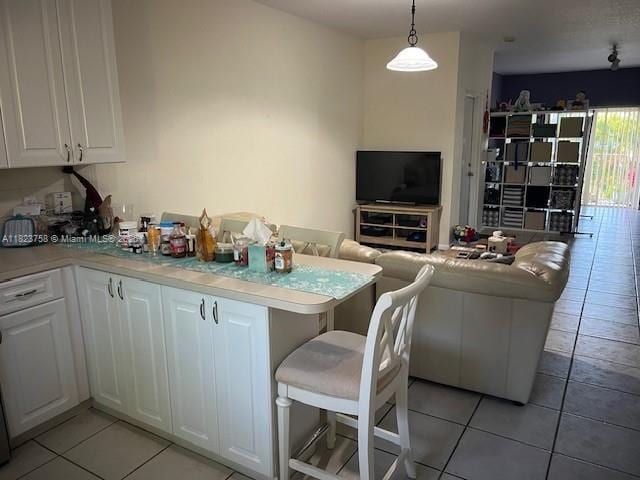 4812 Washington St Unit 8, Hollywood, FL 33021 - kitchen featuring light tile patterned floors, white cabinetry, open floor plan, and light countertops