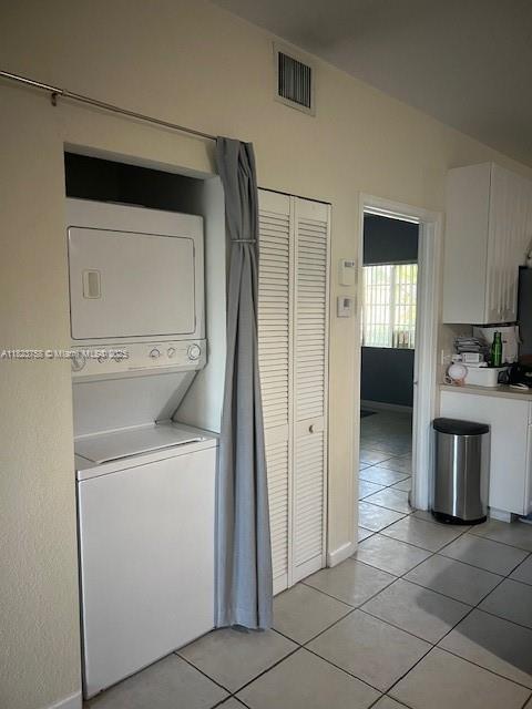 4812 Washington St Unit 8, Hollywood, FL 33021 - washroom with estacked washer and dryer and light tile patterned floors