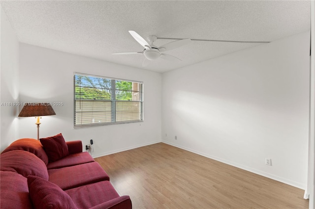 1704 Andros Isle Unit C2, Coconut Creek, FL 33066 - living room with a textured ceiling, light wood finished floors, and a ceiling fan