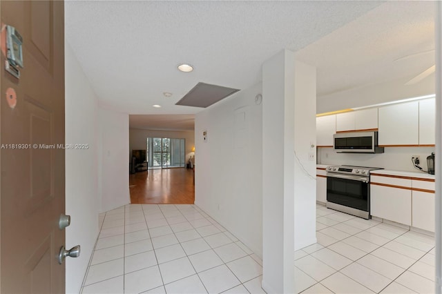 1704 Andros Isle Unit C2, Coconut Creek, FL 33066 - kitchen featuring appliances with stainless steel finishes, white cabinets, light countertops, light tile patterned floors, and recessed lighting