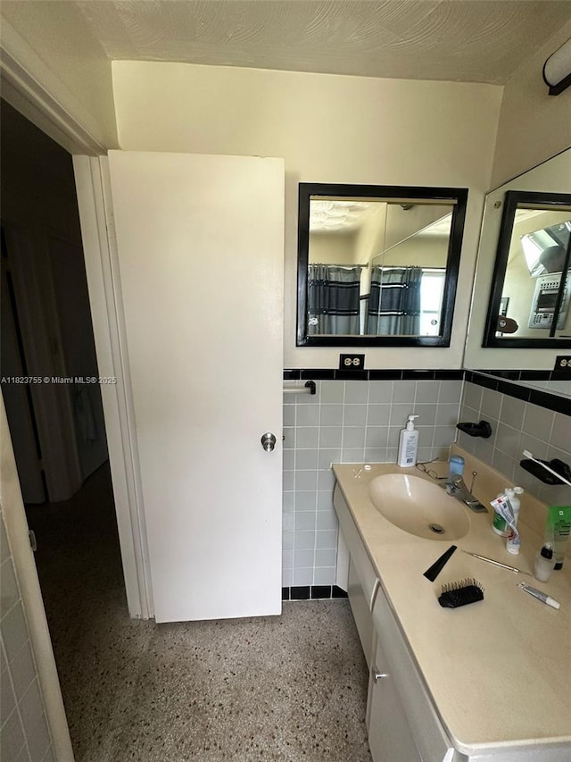 3180 NE 10th Ter, Pompano Beach, FL 33064 - full bath featuring tile walls, speckle patterned floor, vanity, and wainscoting