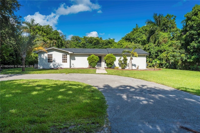 10901 SW 31st St, Davie, FL 33328 - ranch-style house with a front lawn, curved driveway, view of scattered trees, and stucco siding