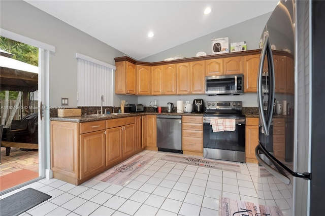 4731 NW 7th Mnr, Coconut Creek, FL 33063 - kitchen with appliances with stainless steel finishes, vaulted ceiling, light tile patterned floors, dark stone counters, and recessed lighting