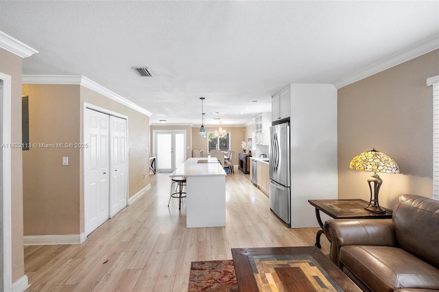 2309 SW 62nd Ct, Miami, FL 33155 - kitchen featuring freestanding refrigerator, a kitchen breakfast bar, light wood finished floors, light countertops, and an island with sink