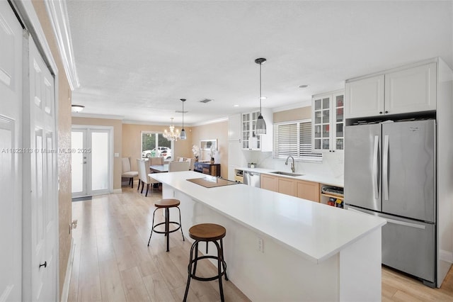 2309 SW 62nd Ct, Miami, FL 33155 - kitchen featuring stainless steel appliances, ornamental molding, a kitchen breakfast bar, glass insert cabinets, and light wood-type flooring