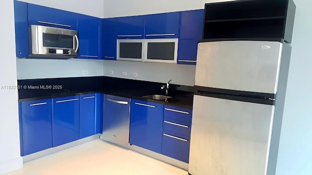 253 NE 2nd St Unit 222, Miami, FL 33132 - kitchen featuring appliances with stainless steel finishes, blue cabinetry, dark countertops, and modern cabinets