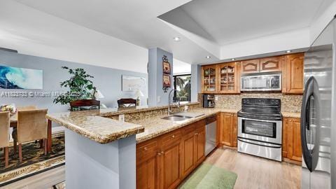 200 Leslie Dr Unit 407, Hallandale Beach, FL 33009 - kitchen featuring stainless steel appliances, a peninsula, brown cabinets, glass insert cabinets, and recessed lighting