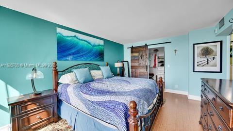 200 Leslie Dr Unit 407, Hallandale Beach, FL 33009 - bedroom with a barn door and wood finished floors