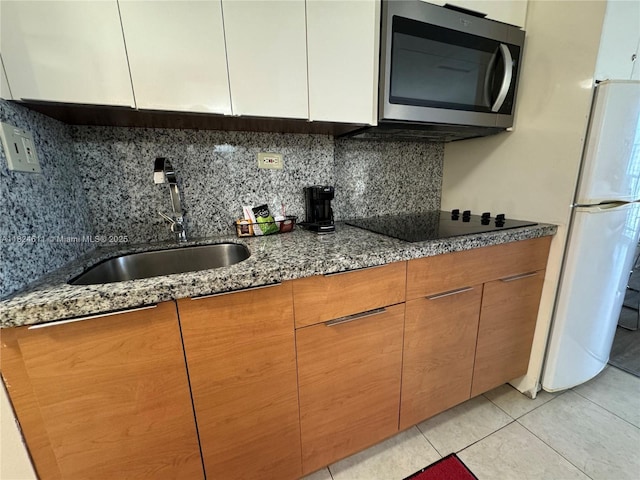 19201 Collins Ave Unit 1137, Sunny Isles Beach, FL 33160 - kitchen featuring stainless steel microwave, dark stone countertops, black electric stovetop, and backsplash