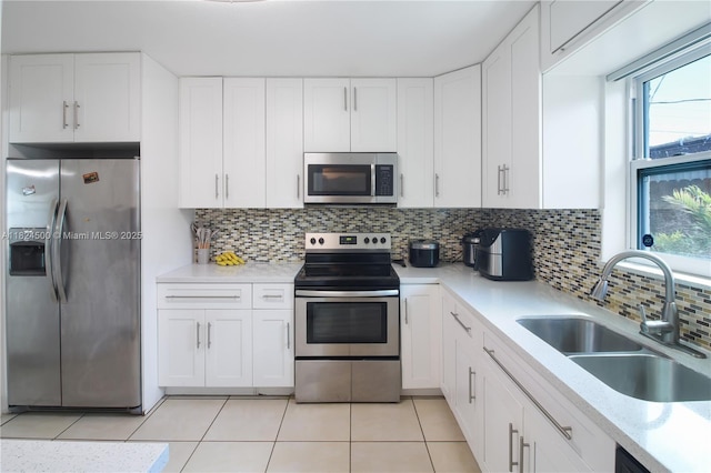6459 Evans St, Hollywood, FL 33024 - kitchen featuring stainless steel appliances, light countertops, white cabinetry, decorative backsplash, and light tile patterned floors