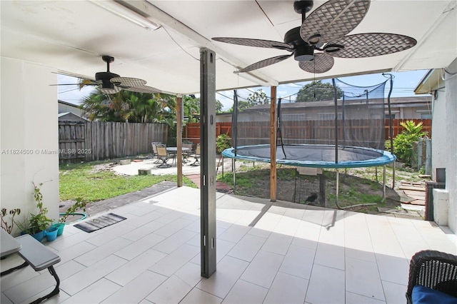 6459 Evans St, Hollywood, FL 33024 - fenced backyard featuring a ceiling fan, a trampoline, and a patio area