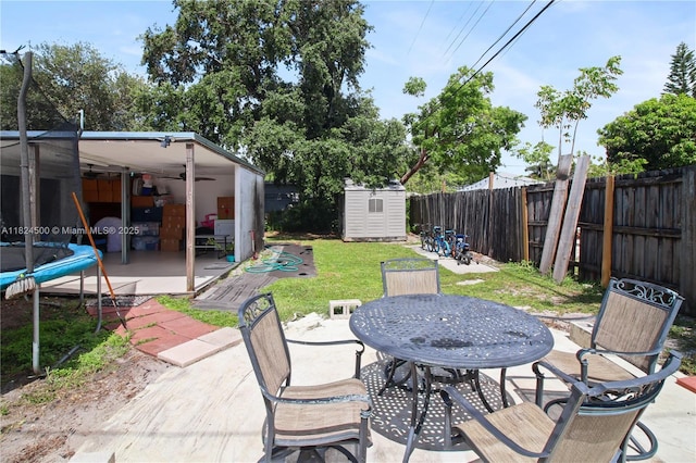 6459 Evans St, Hollywood, FL 33024 - fenced backyard featuring a patio, outdoor dining space, a storage unit, and a ceiling fan
