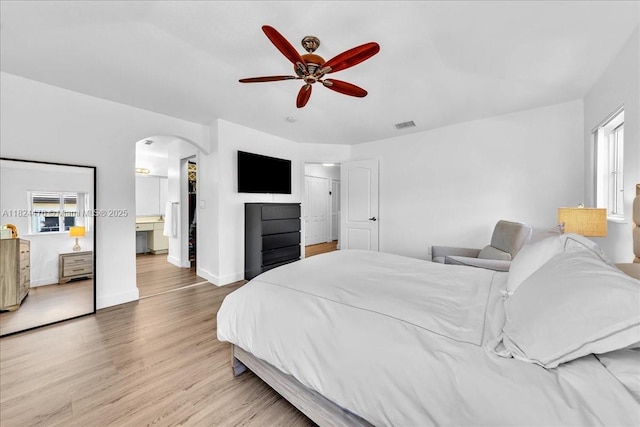 12926 SW 50th St, Miramar, FL 33027 - bedroom featuring arched walkways, light wood-style flooring, ensuite bathroom, and a ceiling fan