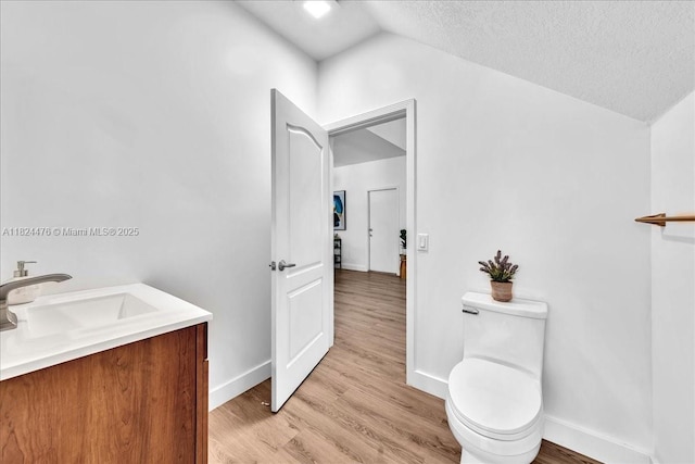 12926 SW 50th St, Miramar, FL 33027 - bathroom featuring vaulted ceiling, wood finished floors, vanity, and a textured ceiling