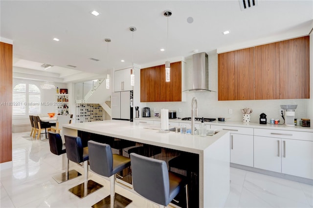 8965 NW 174th Ln, Hialeah, FL 33018 - kitchen with wall chimney exhaust hood, modern cabinets, freestanding refrigerator, a kitchen breakfast bar, and light countertops