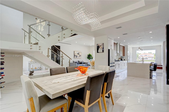 8965 NW 174th Ln, Hialeah, FL 33018 - dining space featuring a chandelier, light marble finish flooring, stairs, recessed lighting, and a tray ceiling