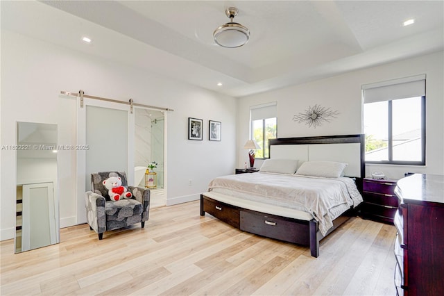 8965 NW 174th Ln, Hialeah, FL 33018 - bedroom featuring a barn door, light wood-type flooring, a tray ceiling, and recessed lighting