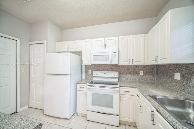 2903 SE 15th Ter, Homestead, FL 33035 - kitchen with white appliances, white cabinets, light tile patterned flooring, light countertops, and backsplash
