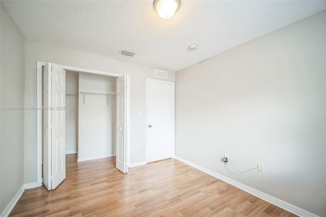 2903 SE 15th Ter, Homestead, FL 33035 - unfurnished bedroom with light wood finished floors, a closet, and a textured ceiling
