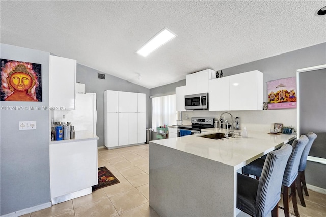 530 SW 182nd Way, Pembroke Pines, FL 33029 - kitchen featuring stainless steel appliances, vaulted ceiling, a peninsula, light countertops, and a breakfast bar