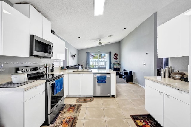 530 SW 182nd Way, Pembroke Pines, FL 33029 - kitchen featuring appliances with stainless steel finishes, a peninsula, a textured ceiling, light tile patterned floors, and light countertops