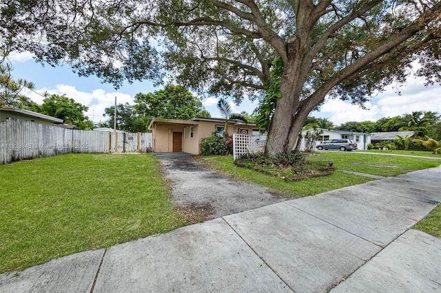 4625 SW 32nd Dr, West Park, FL 33023 - view of front of property featuring driveway, a fenced front yard, stucco siding, a carport, and a gate
