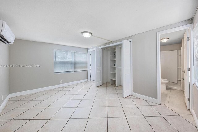 4625 SW 32nd Dr, West Park, FL 33023 - unfurnished bedroom with light tile patterned flooring, a wall unit AC, a closet, and ensuite bathroom