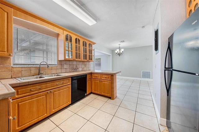 4625 SW 32nd Dr, West Park, FL 33023 - kitchen with freestanding refrigerator, black dishwasher, a chandelier, backsplash, and a peninsula