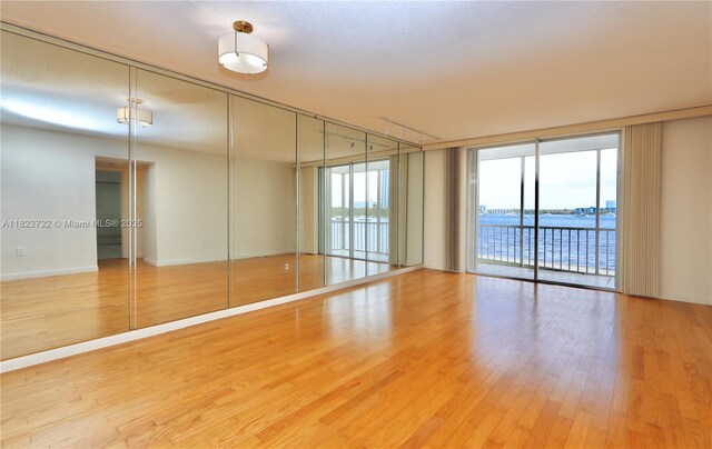 2920 Point E Dr Unit N208, Aventura, FL 33160 - empty room featuring floor to ceiling windows, wood finished floors, and a water view